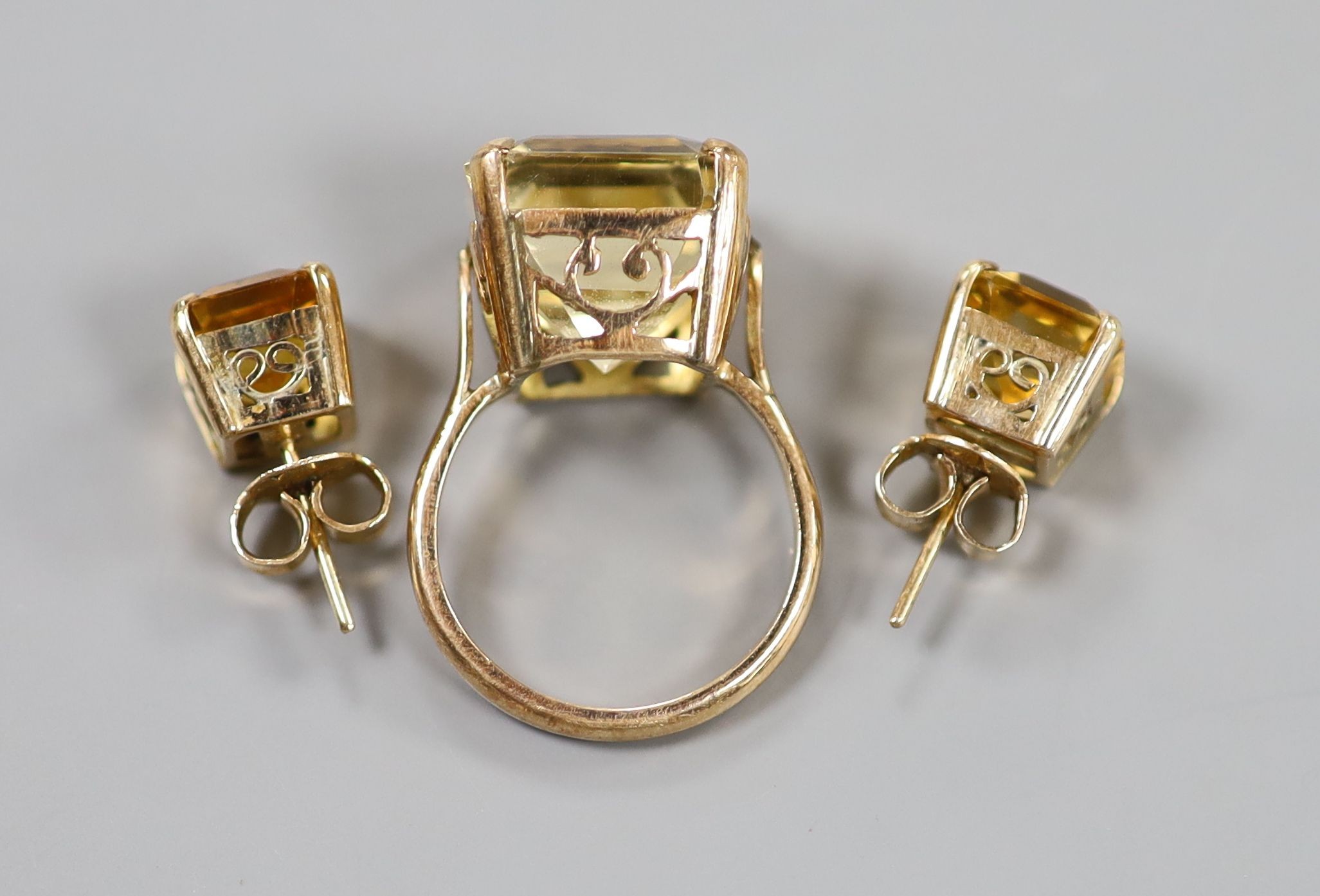 A yellow metal and citrine set dress ring, size K and a pair of similar ear studs, gross weight 10 grams.